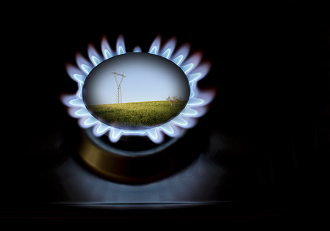 gas burner stove element lit with image of hydro tower in field on sunny day in the middle